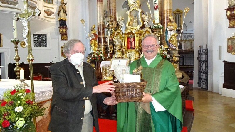Pfarrer Georg Englmeier überreichte beim Abschiedsgottesdienst einen Korb voll guter Wünsche an Hans-Peter Kaiser.