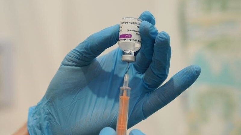Medizinisches Personal befüllt eine Spritze mit einem Corona-Impfstoff.