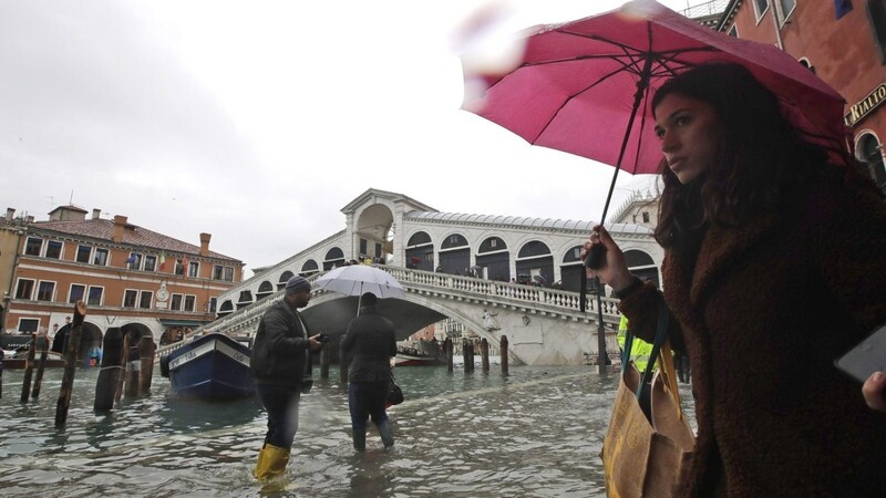 Passanten laufen nahe der Rialto-Brücke durch das Hochwasser. Die Flut erreichte am Dienstag um 10:35 Uhr einen Höchststand von 127 cm.