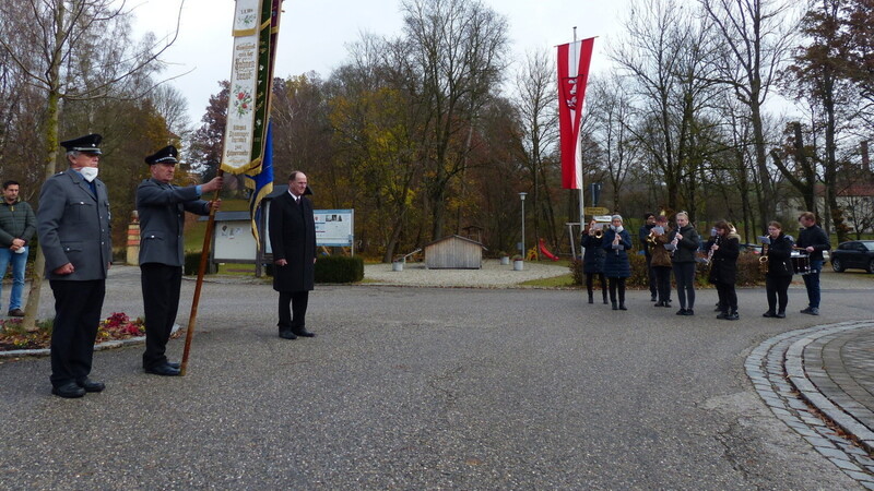 Die Fahnenabordnung der Krieger- und Soldatenkameradschaft, Bürgermeister Johann Ziegleder und die Hofmarkmusikanten (von links) beim Gedenkakt am Kriegerdenkmal .