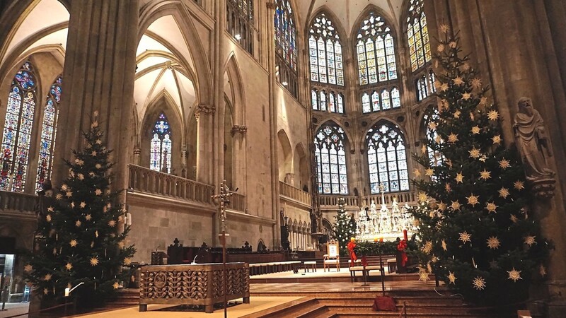 Die Abstände der Strohsterne an den Christbäumen werden abgemessen. Nur so ergibt sich der ruhige, festliche Anblick aus jedem Winkel der Kirche.
