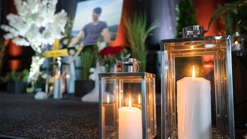 Kerzen, ein Portrait und ein Kreuz mit dem Namen des getöteten Tankstellen-Mitarbeiters stehen bei der Trauerfeier auf der Bühne.