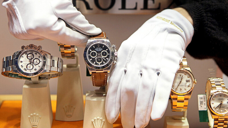 Mit Handschuhen werden Uhren der Marke Rolex in einem Schaufenster platziert. Einige Luxusuhren sind lukrative Renditeobjekte.