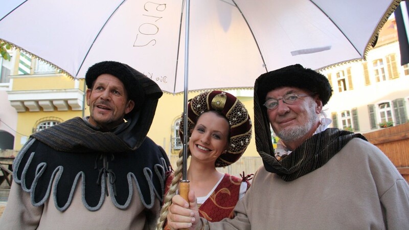 Die Herren Mittelalter-Butler sorgen sich um ihre Herrin: Manfred Gruber (links) und Franz Fuchsbüchler überreichten vor der Generalprobe Ritterin Tina Pohmer einen Schirm gegen die Sonne.