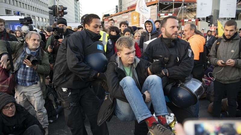 Aktivisten der Klimabewegung Extinction Rebellion werden von der Berliner Polizei weggetragen. Zuvor hatten sie über Stunden auf der Kreuzung am Potsdamer Platz zusammen gesessen und gestanden.
