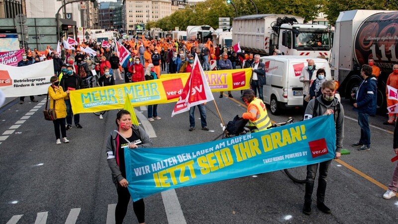 Teilnehmer einer Kundgebung der Gewerkschaft Verdi zu Warnstreiks im öffentlichen Dienst stehen mit einem Banner mit dem Slogan "Jetzt seid ihr dran" auf dem Jungfernstieg.