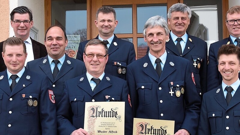 Fred Wiester (vorne, 2.v.l.) und Feuerwehr-Vorsitzender Wolfgang Hadersdorfer (vorne, 3.v.l.) wurden für 40-jährige aktive Dienstzeit geehrt. Die Feuerwehrführung und Bürgermeister Karl Ecker gratulierten.