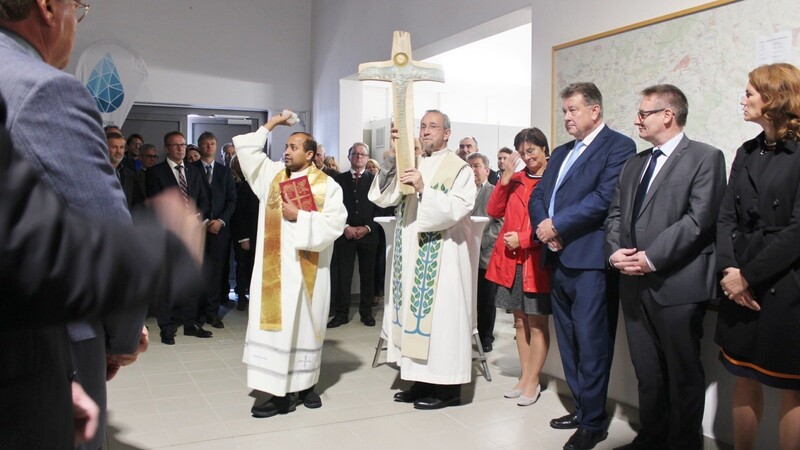 Den Segen für das neue Werk und das kunstvoll geschnitzte Kreuz spenden die beiden Geistlichen Pater Michael Raj und Pfr. Jörg Gemkow (rechts).