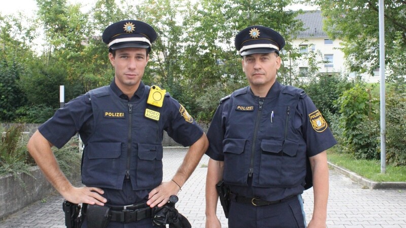 Die gelben Bodycams heben sich deutlich von der dunkelblauen Uniform der Polizei ab.