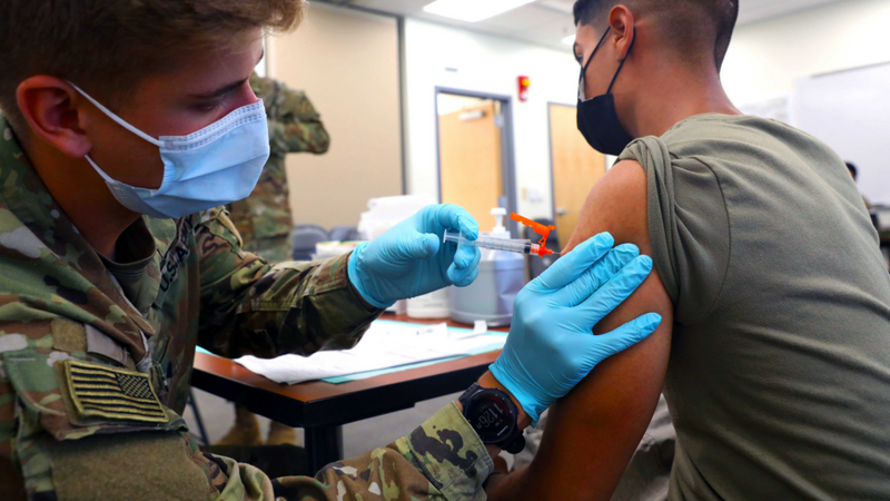 Ein US-Sanitäter impft einen amerikanischen Soldaten gegen Corona (Symbolbild).