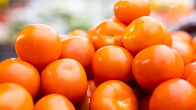 Tomaten werden an einem Stand auf einem Wochenmarkt angeboten.