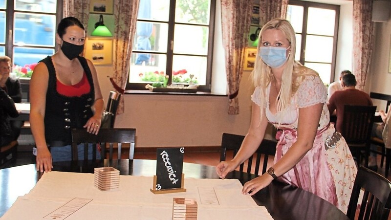Die "Arcobräu Stuben"-Bedienungen Alexa (l.) und Tina bereiten unter Auflagenbeachtung den Tisch für die nächsten Gäste vor.