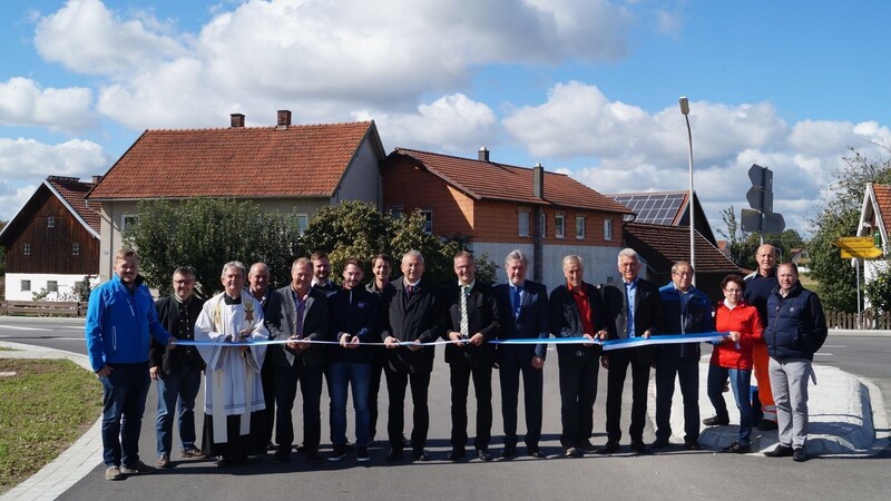 Die Vertreter von Landkreis, Gemeinde und den beteiligten Baufirmen gemeinsam mit Pfarrer Reinhard A. Röhrner, Landrat Josef Laumer und Bürgermeister Johann Grau bei der offiziellen Verkehrsfreigabe.