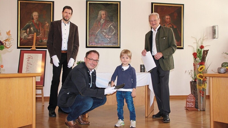 Dr. Wolf Schoyerer (rechts) und Enkel Lennart übergeben den Säbel an Bürgermeister Martin Stoiber (Zweiter von links) und Stadtarchivar Timo Bullemer.