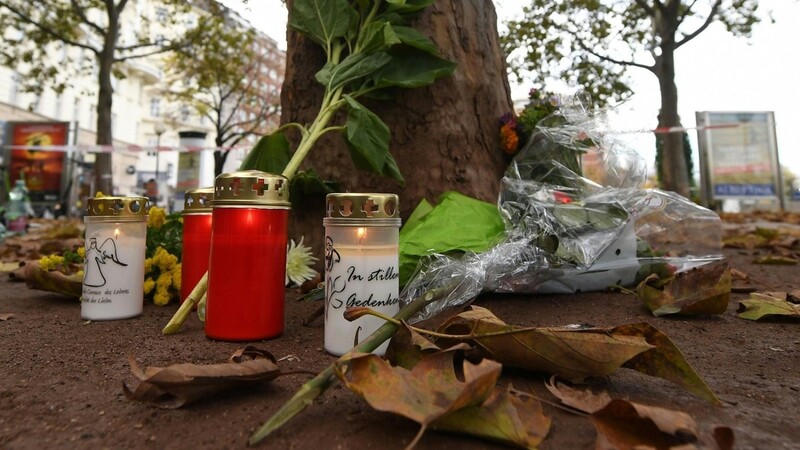Kerzen und Blumen liegen im Bereich des Tatorts einer Terror-Attacke zum Gedenken an die Opfer.