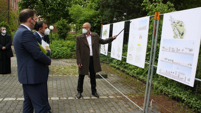Architekt Andreas Eckl erläutert Staatsminister Klaus Holetschek und Bürgermeister Martin Stoiber (von rechts) die Pläne fürs Seniorenheim.