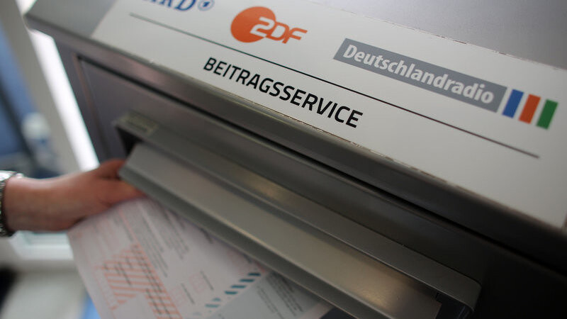 Eine Frau wirft am 17.06.2015 in Köln (Nordrhein-Westfalen) beim Beitragsservice von ARD, ZDF und Deutschlandradio einen Fragebogen in den Briefkasten.