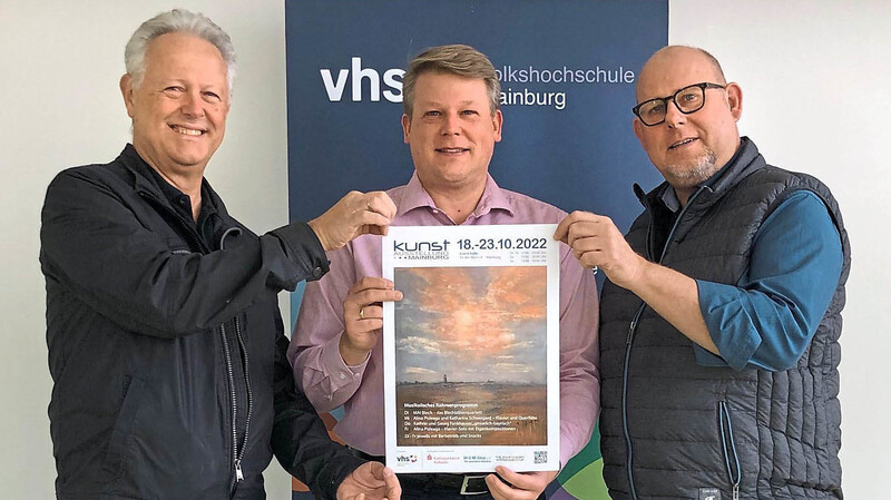 Die Mainburger Kunstausstellung findet nach zwei virtuellen Jahren wieder in Präsenz statt. Die Planungsgruppe mit dem Leiter der Gruppe Kunst, Wolfgang Dangl, Vhs-Geschäftsführer Matthias Bendl und Pfarrer Frank Möwes präsentiert das Plakat.