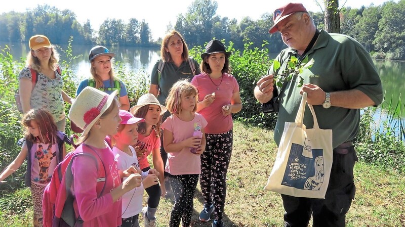 Naturschutzwart Jürgen Tauer (r.) zeigte den interessierten Teilnehmern an einem Erlenzweig die Fruchtstände.