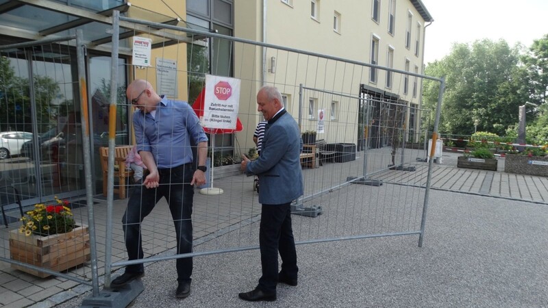 Bürgermeister Josef Reff (rechts) und Heimleiter Stephan Kronzucker entfernten in einem symbolischen Akt den Bauzaun vor dem Eingangsbereich des Seniorenheims.