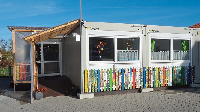 Schon von außen lassen die bunten Zaunlatten den Container-Kindergarten fröhlich erscheinen.