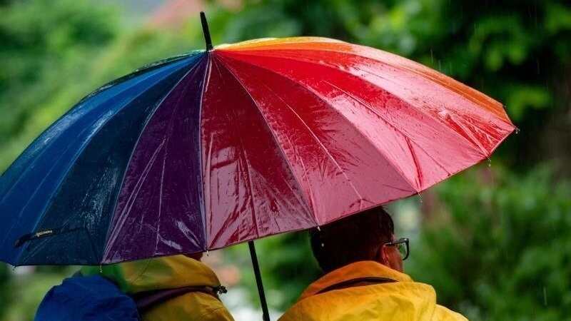 Spaziergänger sind bei Regenwetter mit einem Regenschirm unterwegs.
