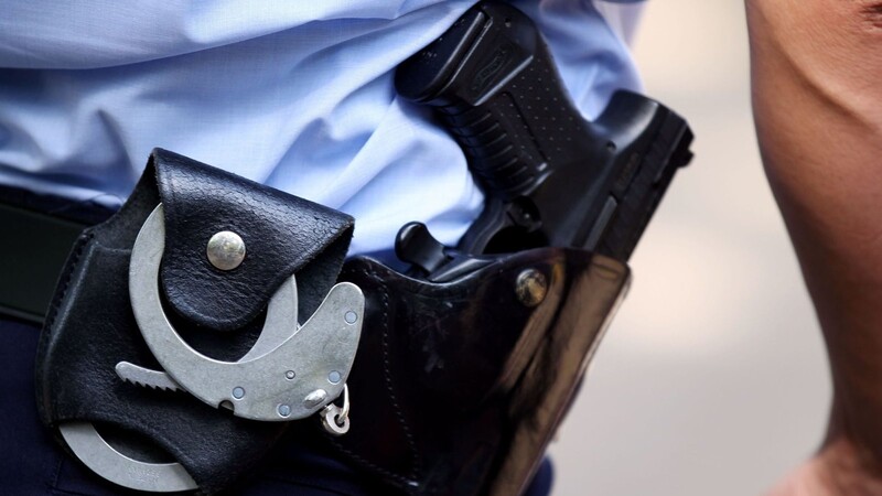 Ein Polizist trägt Handschellen bei sich: Die Bundespolizei hat mutmaßliche Schleuser festgenommen.