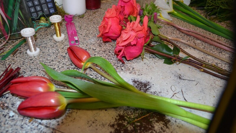 Gute Vorbereitung ist alles: Sandra Wanninger hat die "Highlights" für den Strauß - Tulpen und Rosen in leuchtendem Rot sowie weiße Iris - bereitgelegt.