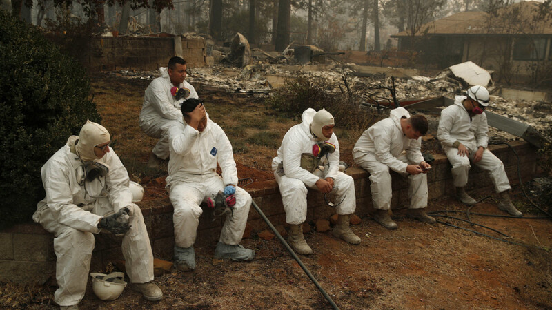 Erschöpfte Einsatzkräfte in einem ausgebrannten Garten in Kalifornien.