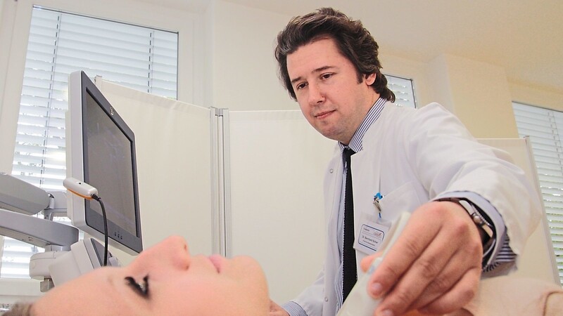 Dr. Bernhard Scher, Leiter des Schilddrüsenzentrums und Chefarzt der Klinik für Nuklearmedizin, untersucht mit Ultraschall die Schilddrüse einer Patientin.