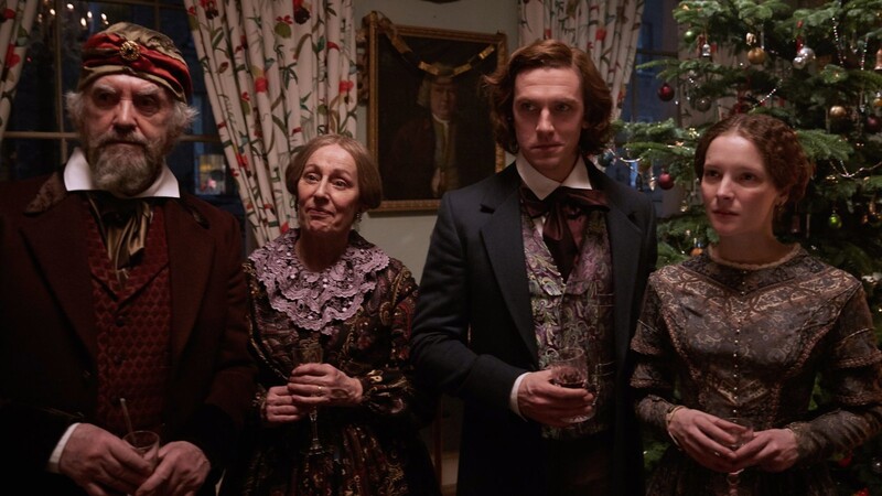 Dan Stevens als Charles Dickens (r.) mit seinem Vater (Jonathan Pryce), seiner Mutter und Frau vor einem "deutschen Weihnachtsbaum", wie seiner Familie erklärt.