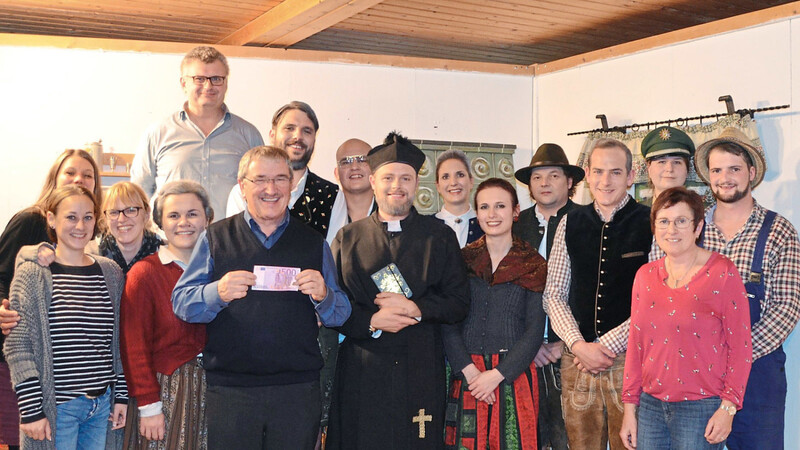 Nach der Vorstellung überraschten die Theaterspieler Pfarrer Werner Gallmeier mit einem Scheck über 500 Euro für die Indiohilfe.
