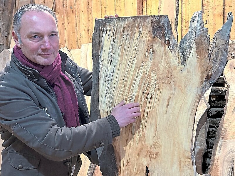 Holzliebhaber Christian Kreipl zeigt auf die flammende Struktur in der Bohle der Rosskastanie. 