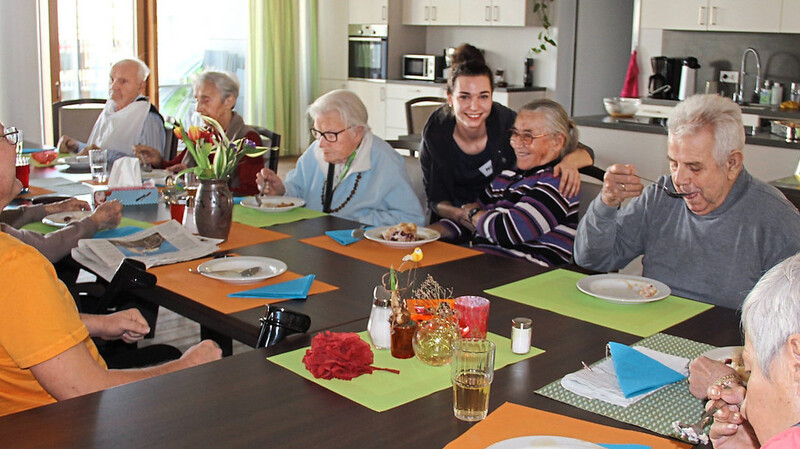 Mittags und abends treffen sich die Senioren im Wohnzimmer zum Essen, das in der Wohnküche gekocht wird. Ansonsten können sie ihre Freizeit verbringen, wie sie wollen. Nikki Krinner (Mitte) und Sandy Hummel (im Hintergrund) betreuen die Senioren.