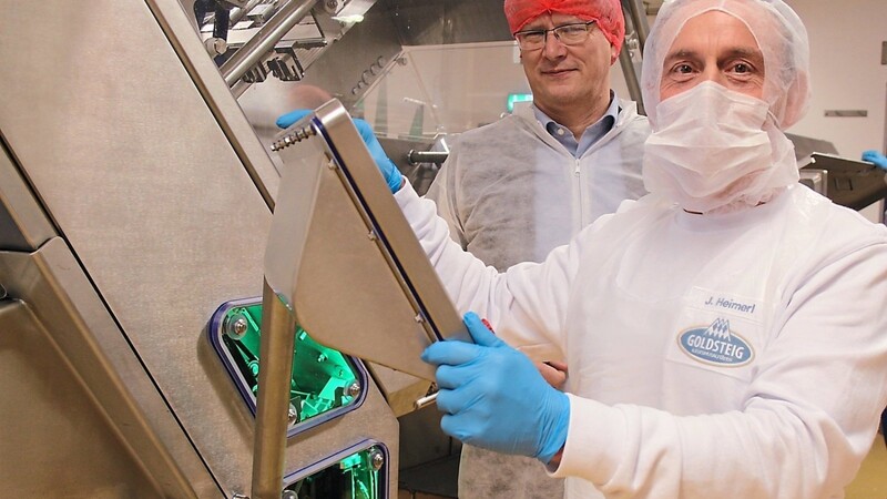 Josef Heimerl bedient eine Maschine bei den Goldsteig-Käsereien Bayerwald GmbH. Er verstärkt seit zwei Monaten das Team in der Produktion. Markus Nitsch von der Agentur für Arbeit in Schwandorf freut sich, dass der Schwerbehinderte eine Anstellung gefunden hat.