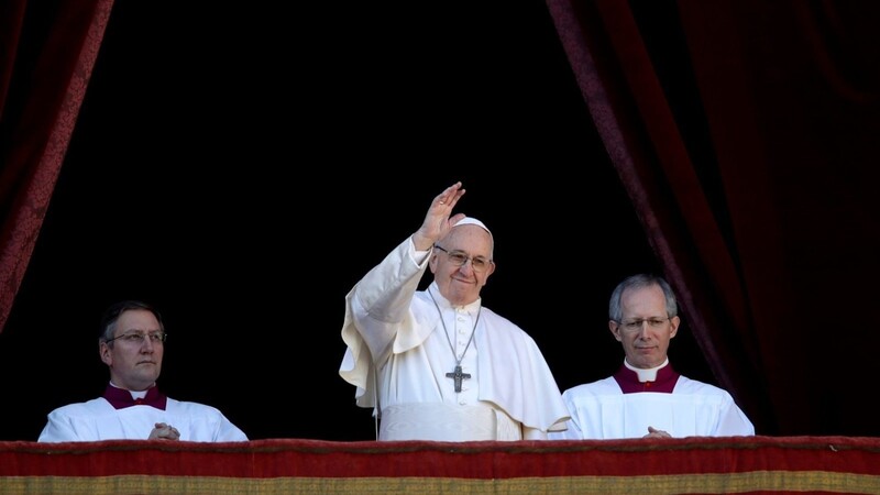 Papst Franziskus (M), flankiert vom Zeremonienmeister Bischof Guido Marini (r), winkt nach dem Urbi et Orbi (lateinisch für "Der Stadt und dem Erdkreis") Weihnachtssegen vom Hauptbalkon der Peterskirche im Vatikan.