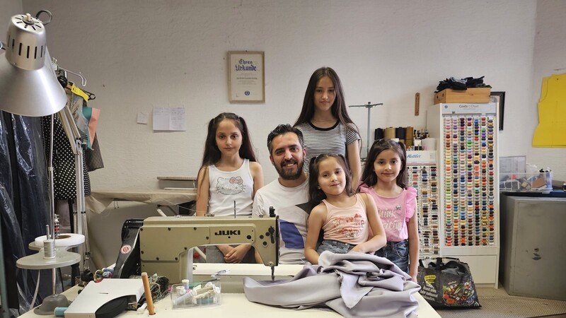 Mohammed Eid Alnajjar in der Nähstube der Familie Ziegelhöfer zusammen mit seinen vier Töchtern Ansam (v. l.), Cham und Weam. Auf seinem Schoß Tochter Salam.
