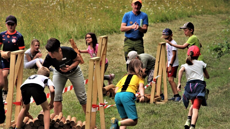 Beim Holzaufrichten geht's auf Zeit und dafür feuern sich die Kinder gegenseitig lautstark an.