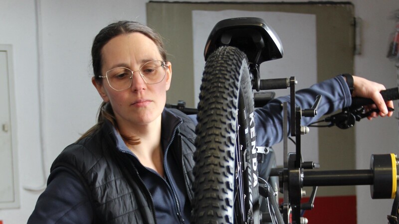 Uschi Hilmer repariert ein E-Bike in der Werkstatt.