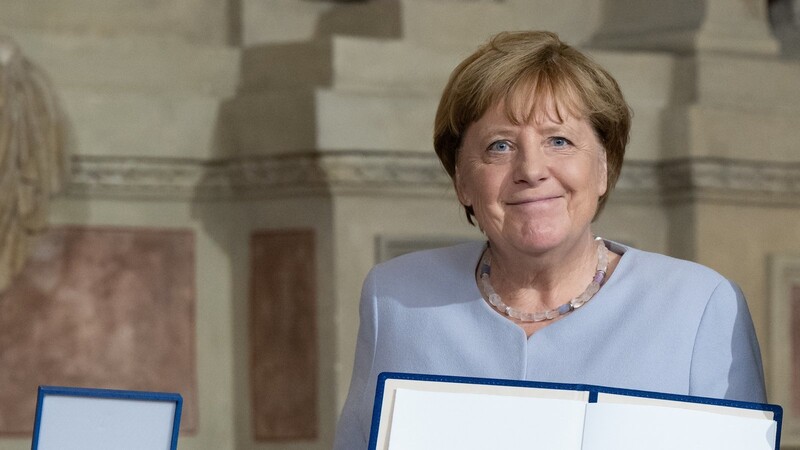 Angela Merkel (CDU) hält in der Münchner Residenz den bayerischen Verdienstorden in der Hand, den sie zuvor vom Ministerpräsidenten verliehen bekommen hat.