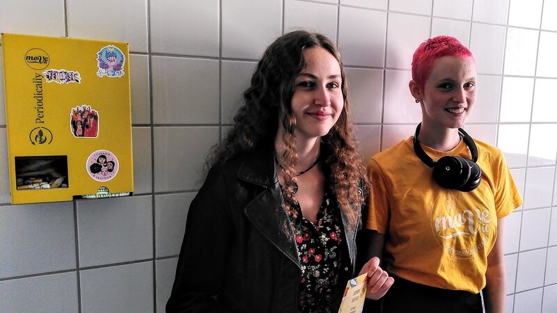 Jana Schneider und Johanna Gruber vom Jugendforum mit einem der neuen Automaten für kostenlose Hygieneartikel.