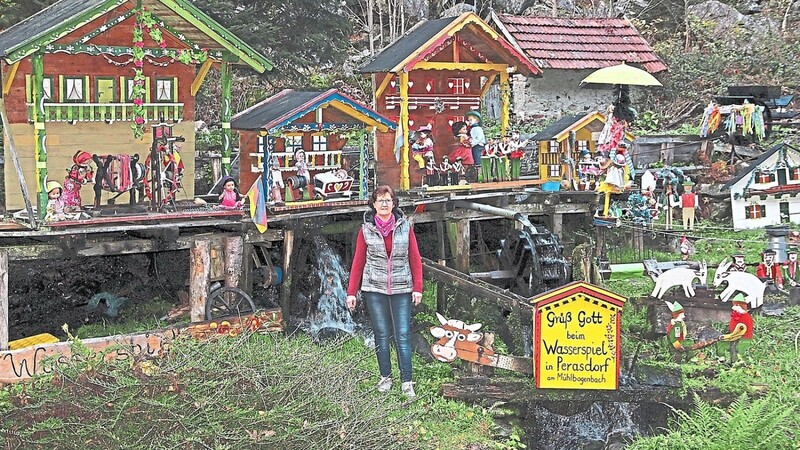 Sieglinde Ettl steht zwischen den Häuschen und Puppen bei den Wasserspielen in Perasdorf.