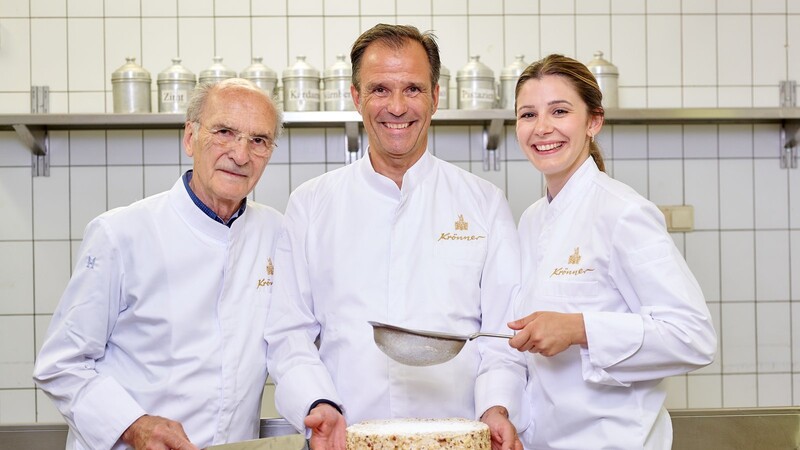 Drei Generationen Krönner - Großvater Josef, Vater Joschi und Tochter Magdalena - mit dem kulinarischen Flaggschiff des Hauses, der Agnes-Bernauer-Torte.