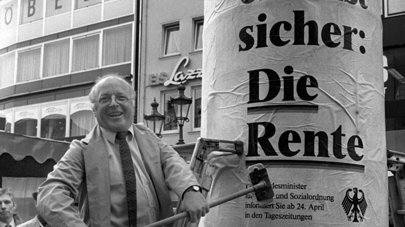 21. April 1986: Eigenhändig geift der damalige Bundesarbeitsminister Norbert Blüm (CDU) auf dem Bonner Marktplatz zum Leimpinsel, um das erste Plakat einer Informationsaktion zur Sicherheit der Renten auf eine Litfaßsäule zu kleben. Der Text des Plakates lautet: "denn eins ist sicher: Die Rente".