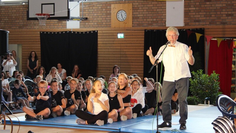 Zusammen mit den Schülern singt Josef Messerer das Grundschul-Bobfahrerlied.
