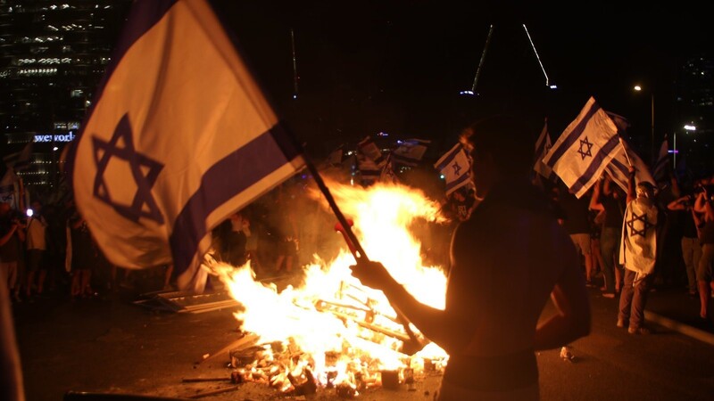 Demonstranten zünden ein Feuer an während eines Protests gegen die Justizreform.