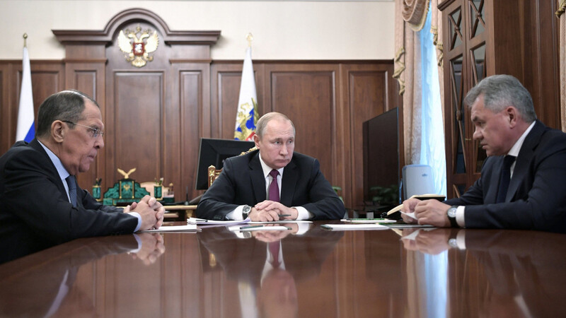 Wladimir Putin (M.) nimmt an einem Treffen mit Außenminister Sergej Lawrow (l.) und Verteidigungsminister Sergei Schoigu im Kreml teil.
