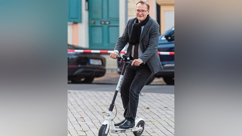 Oberbürgermeister Andreas Starke (SPD) testet die Roller aus.