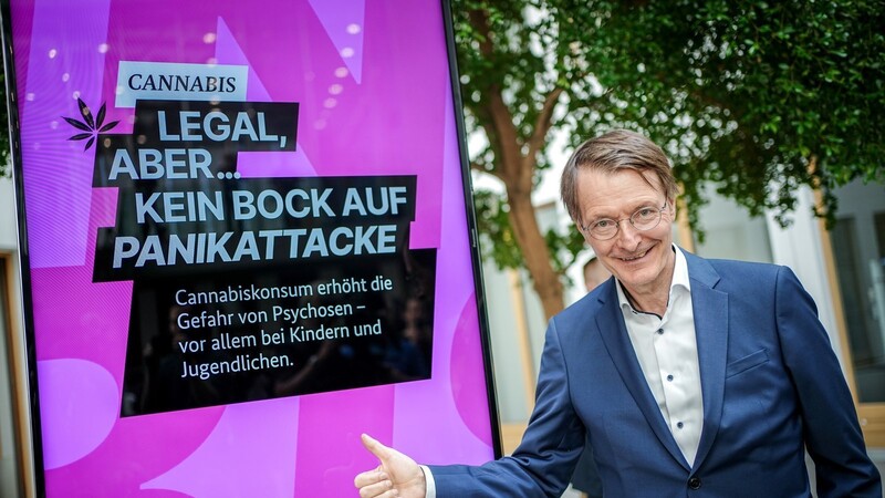 Karl Lauterbach (SPD), Bundesminister für Gesundheit, steht zu Beginn der Pressekonferenz zum Cannabis-Gesetz neben einer Werbeanzeige seines Ministeriums zum Cannabis-Konsum.
