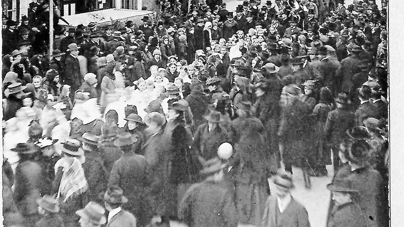 Krieger-Heimkehrfeier am 26. Januar 1919 vor dem Rathaus (linkes Gebäude, nebenan die Firma Ziegler). Auf dem Foto ist die Aufstellung für den Festzug in die Pfarrkirche zu sehen. Die Krieger werden von den Ortsvereinen, einer Blaskapelle und der Mädchengruppe begleitet.
